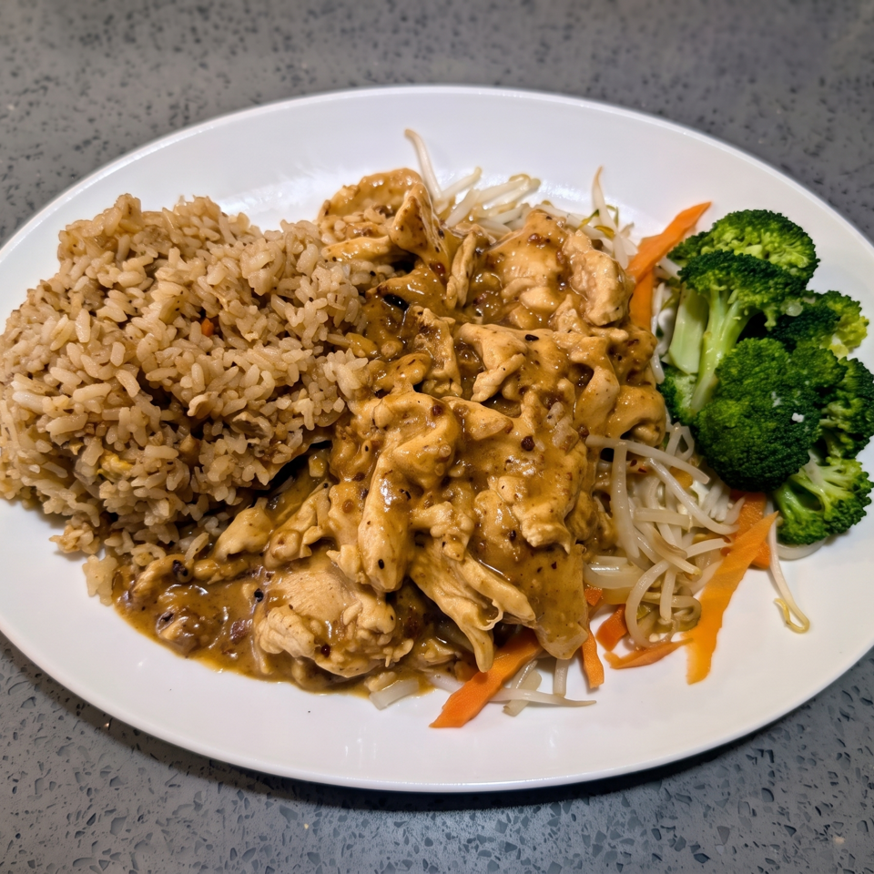 Chicken with black pepper sauce, fried rice, bean sprouts, carrots, and broccoli on a white plate.
